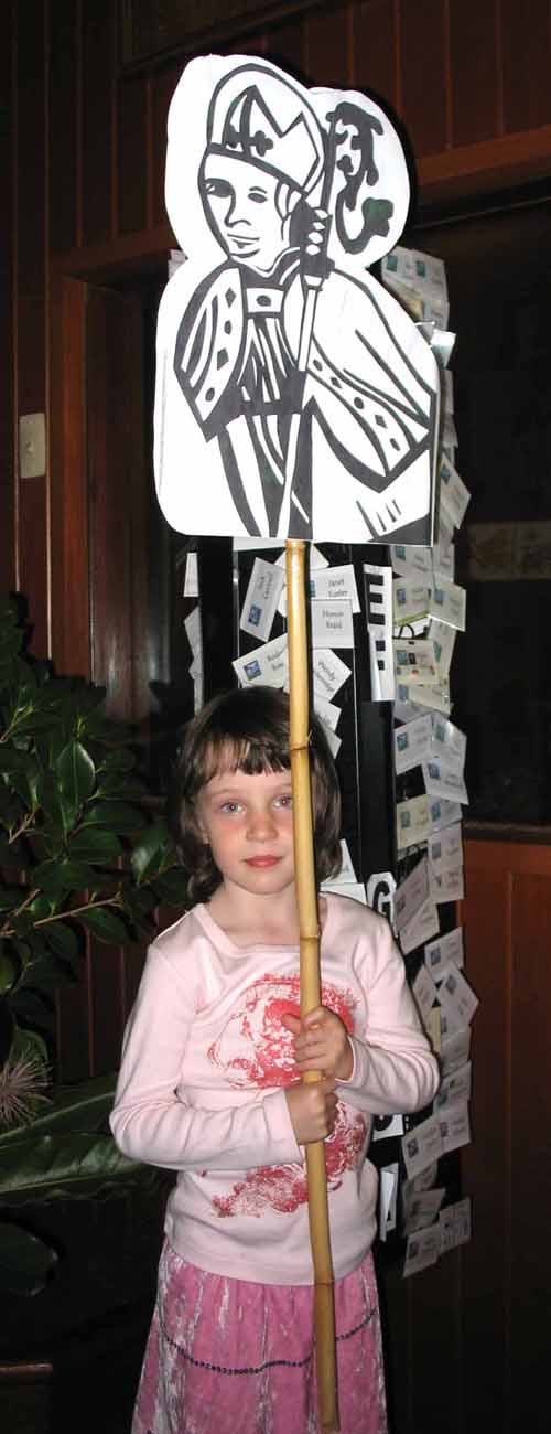 Young girl holding the emblem, with the pole holding the emblem reaching comfortably above her head.